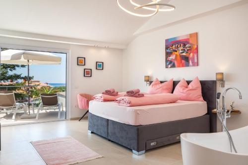 a bedroom with a bed with pink pillows and a tub at Villa Elena Deluxe mit Whirlpool und POOL am MEER in Fažana