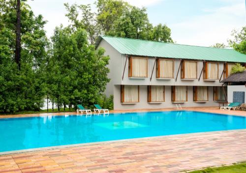 a swimming pool in front of a building at Whistling Woodzs Resort in Dandeli
