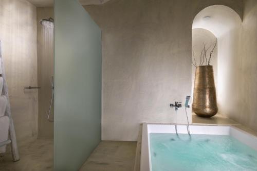 a bathroom with a bath tub with a vase at Mythical Blue Luxury Suites in Fira