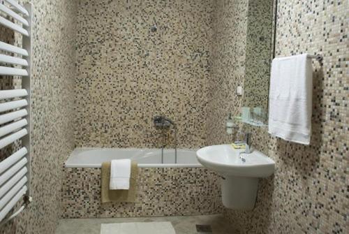 a bathroom with a sink and a toilet and a tub at Kalin Hotel in Lazaropole