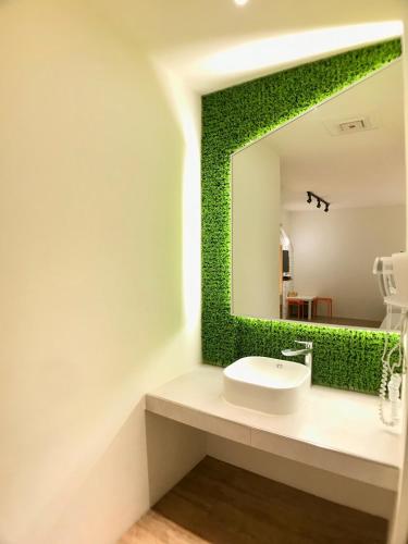 a bathroom with a white sink and a mirror at Martin Wales Inn in Kenting