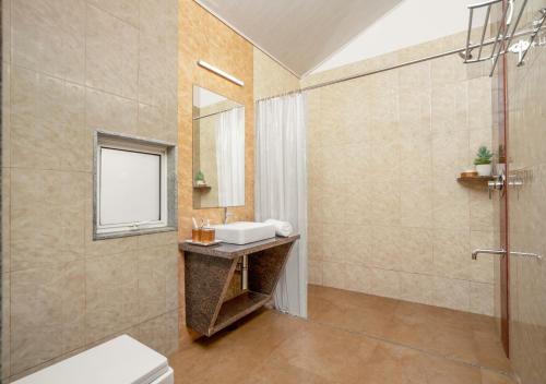 a bathroom with a sink and a shower at Whistling Woodzs Resort in Dandeli