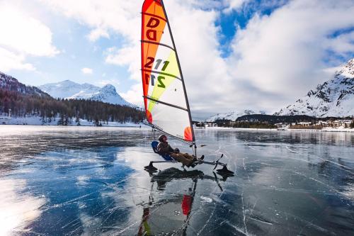 a person is windsurfing on a body of water at Maloja Palace Suites CO2-Neutral in Maloja