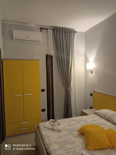 a bedroom with a bed and a yellow cabinet at AFFITTACAMERE BORGATA MARINA in Roseto Capo Spulico