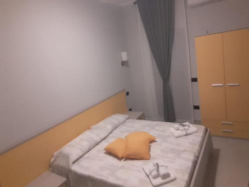 a small bedroom with a bed with shoes on it at AFFITTACAMERE BORGATA MARINA in Roseto Capo Spulico