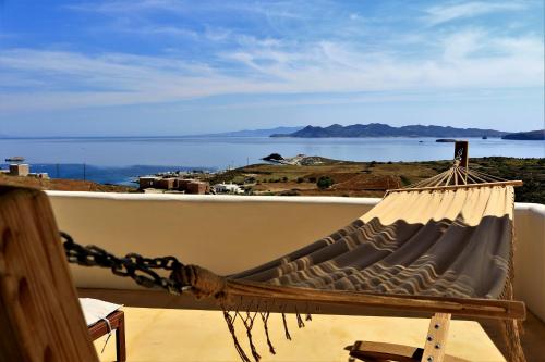 uma rede de descanso numa varanda com vista para o oceano em Aegean Blue Houses em Mandrakia