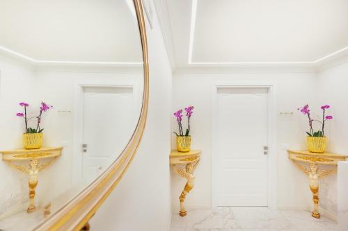 a mirror in a hallway with flowers on a table at Palazzo Marletta Luxury House Hotel in Catania