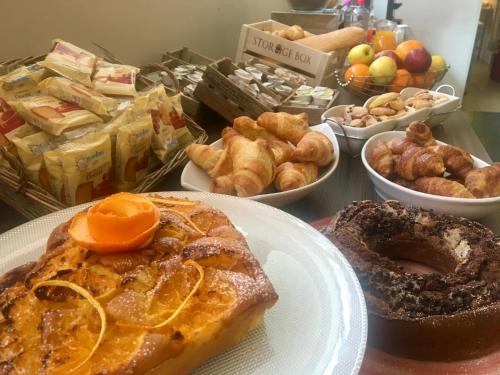 a table topped with plates of breakfast foods and pastries at Hotel Kristall in Orvieto