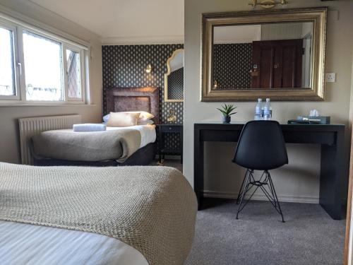um quarto com 2 camas, um espelho e uma cadeira em Adare Guesthouse em Galway