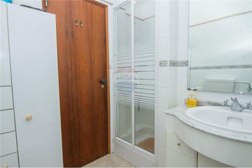 bagno con lavandino e doccia in vetro di Apartamento Quarteira Praia a Quarteira