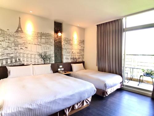 two beds in a hotel room with a mural at Martin Wales Inn in Kenting
