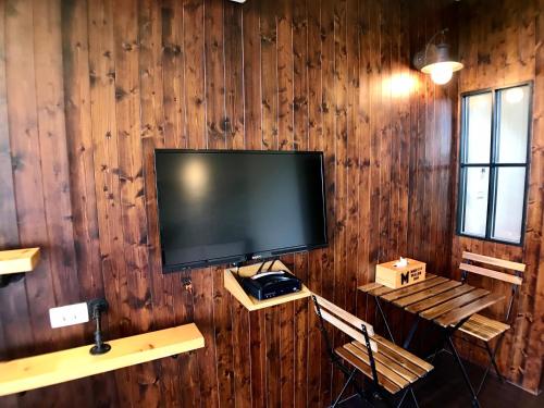 a flat screen tv hanging on a wooden wall at Martin Wales Inn in Kenting