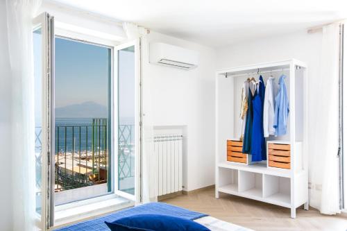 Dieses weiße Zimmer verfügt über ein großes Fenster und ein Ankleidezimmer. in der Unterkunft SeaView Sorrento Apartment by the sea with terrace in Sorrent