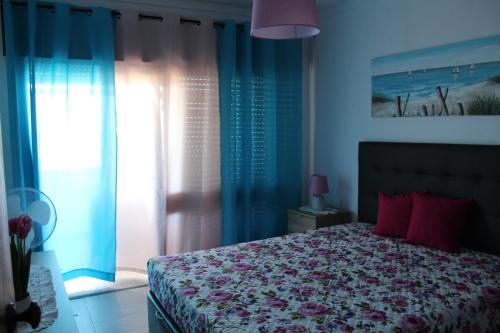 una camera da letto con un letto con cuscini rossi di Apartamento Quarteira Praia a Quarteira