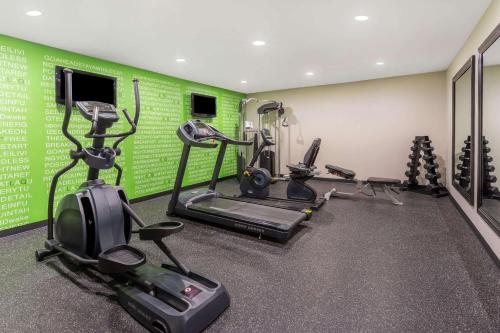 a gym with several tread machines and green walls at La Quinta by Wyndham Rockford in Rockford