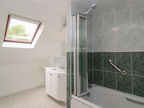 a bathroom with a shower and a tub and a sink at Little Valley View in Hayle