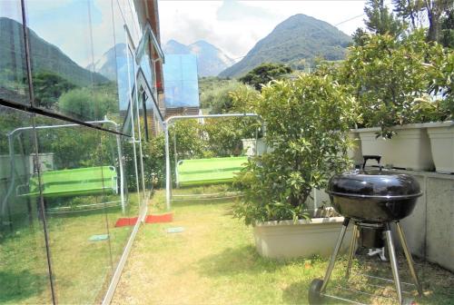 a grill in a garden with mountains in the background at Dock House in Marone