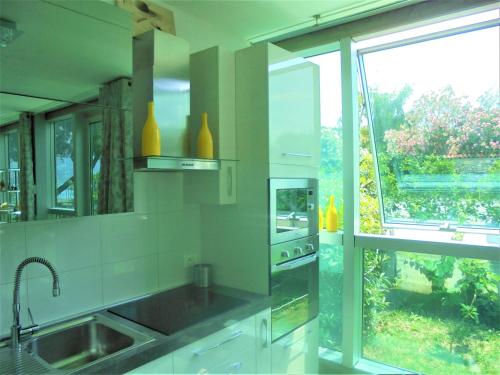 a kitchen with a sink and a large window at Dock House in Marone