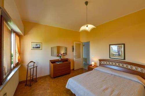 Schlafzimmer mit einem Bett, einer Kommode und einem Spiegel in der Unterkunft Villetta autonoma affacciata sul Golfo Borromeo in Verbania