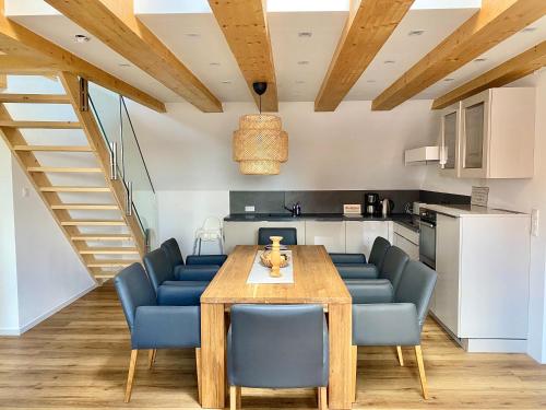 eine Küche und ein Esszimmer mit einem Holztisch und blauen Stühlen in der Unterkunft Apartments bei Playmobil 2,130 m2 in Zirndorf