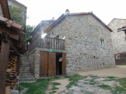 an old stone building with a wooden gate and a door at LE MYRO in Péreyres