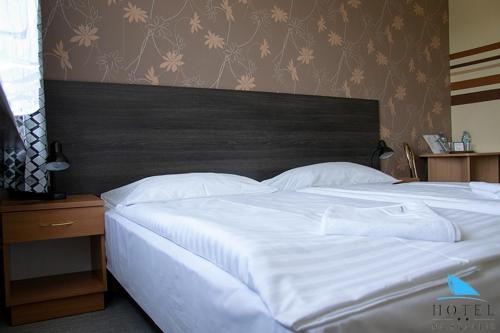 a bedroom with a large white bed with a wooden headboard at Na Skarpie in Olsztyn