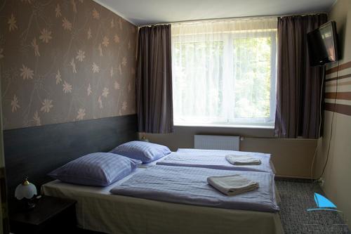 a bedroom with a bed with blue sheets and a window at Na Skarpie in Olsztyn