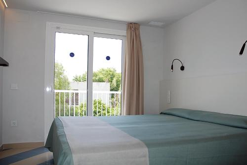 1 dormitorio con cama y ventana grande en Apartamentos Sunway Arizona, en Sitges