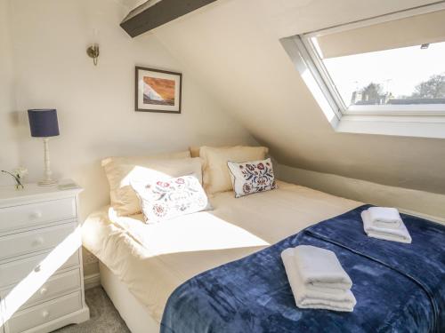 ein kleines Schlafzimmer mit einem Bett und einem Fenster in der Unterkunft Victoria Cottage in Chipping Norton