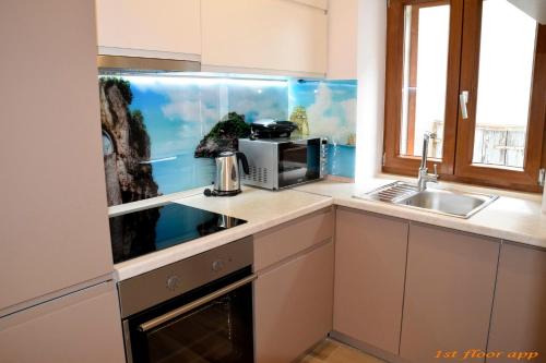 a kitchen with a fish tank next to a sink at Apartments ELA in Piran