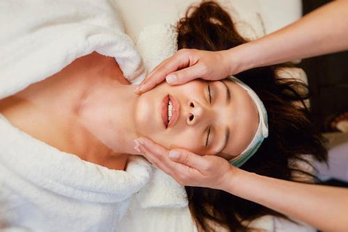 a woman getting her face groomed by a massage therapist at Rodos Park in Rhodes Town