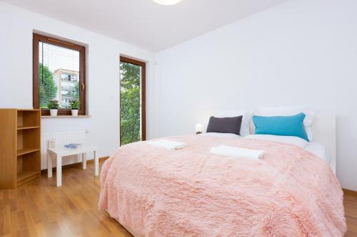 a white bedroom with a large bed and a window at Apartments Platynowa Gdańsk by Renters in Gdańsk