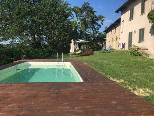 a swimming pool in a yard next to a building at Agriturismo Minaldo in Dogliani