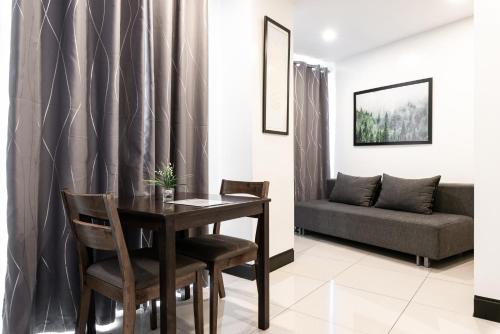 a dining room with a table and a couch at Artemis Place Makati Hotel in Manila