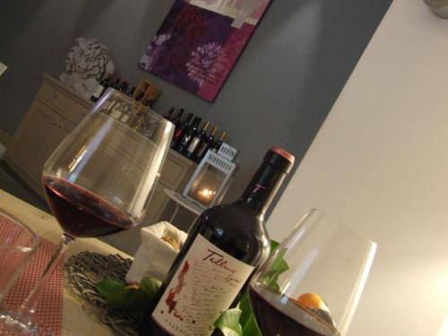 a bottle of wine sitting on a counter with a bowl of food at Hotel Kristall in Orvieto