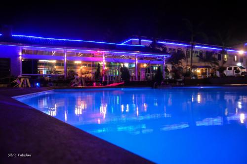 a large swimming pool at night with blue lights at Hotel Morro dos Conventos in Araranguá