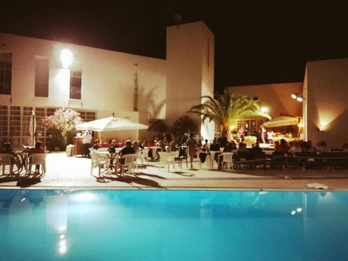 a pool in front of a hotel at night at Hotel Diffuso Montedoro in Montedoro