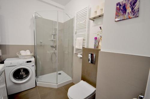 ein Badezimmer mit einer Waschmaschine und einer Waschmaschine in der Unterkunft Apartament harmonic aparts in Polanica-Zdrój