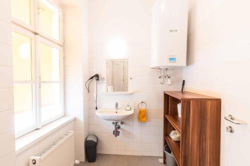 ein weißes Bad mit einem Waschbecken und einem Fenster in der Unterkunft Ferienwohnung Klangturm im Zentrum in Sankt Pölten