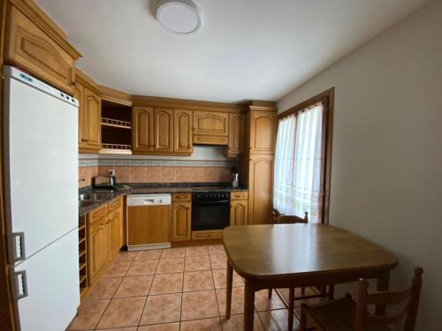 a kitchen with wooden cabinets and a wooden table and a table and a tableearcher at CASA PEDRO BERGUA in Fiscal