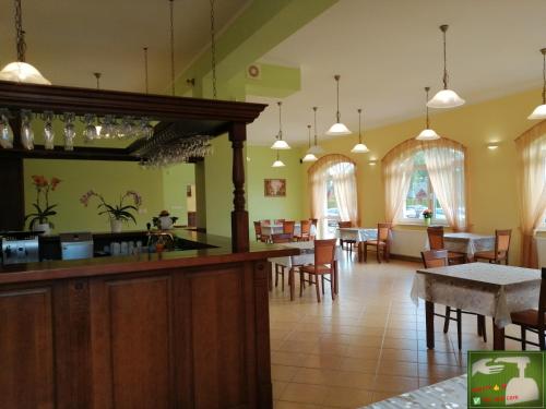 restauracja z barem, stołami i krzesłami w obiekcie Villa Sylvia w Dźwirzynie