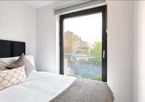 a bedroom with a bed and a large window at Deluxe Central London North Apartment in London