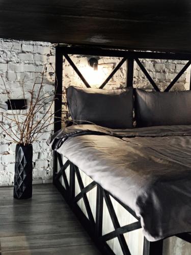 a wooden bed in a room with a brick wall at Luxury_loft in Kamianets-Podilskyi