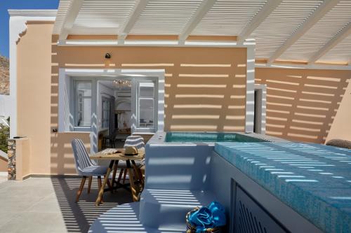 a swimming pool with a table and chairs on a patio at Blue Sea Hotel in Kamari