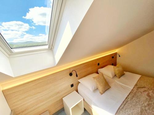 a bedroom with a bed and a window at 16 Lakes Hotel in Grabovac