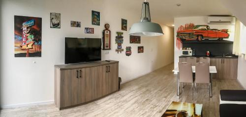 a living room with a flat screen tv and a table and chairs at Motel Eldorado in Mikulov