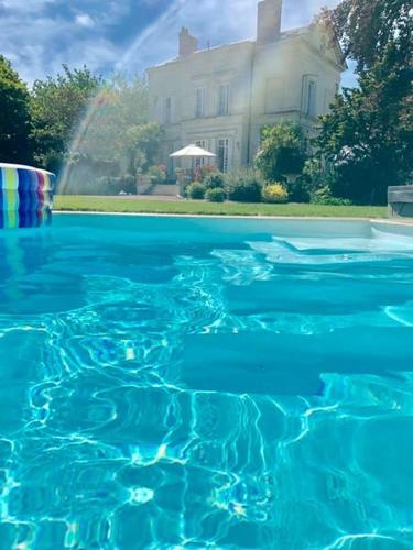 a pool of blue water in front of a house at La gentilhommiere de Saumur in Saumur