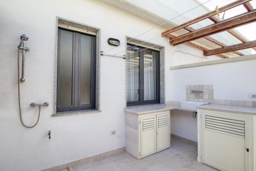 een badkamer met douche en wastafel bij SUNSET GREG - fronte mare San Gregorio by LoveSud in Leuca