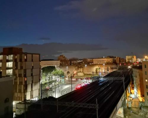 a view of a city at night with train tracks at Porta Maggiore GH Locazione Turistica in Rome