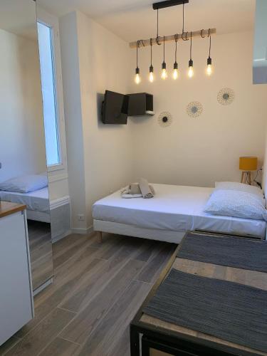 - une chambre avec 2 lits et une télévision murale dans l'établissement Studio Vagliano, à Cannes